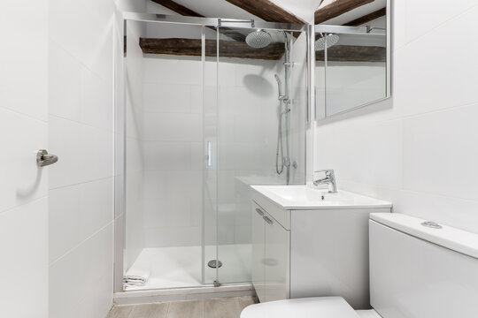 Bathroom with cream marble sink with frameless mirror and access to a bedroom with large window