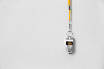 Lifeguard's whistle hanging on light wall, closeup - obrazy, fototapety, plakaty