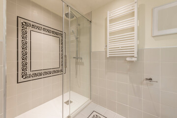 Shower cabin with sliding glass partition and heated towel rail in a vacation rental apartment