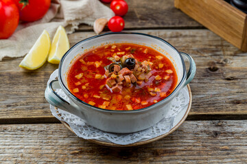 Meat Solyanka soup on old wooden table