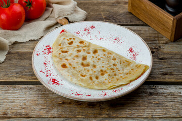 plate with Qutab with potatoes on plate on old wooden table
