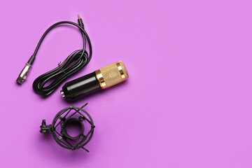 Modern microphone with stand and wire on purple background