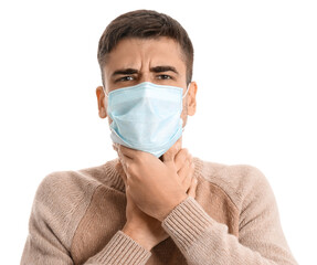 Ill young man with sore throat wearing medical mask on white background