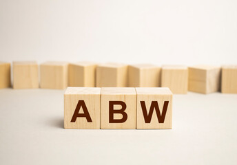 On a wood board, wooden word cubes are arranged in the letters ABW. It is an abbreviation for Activity Based Working.