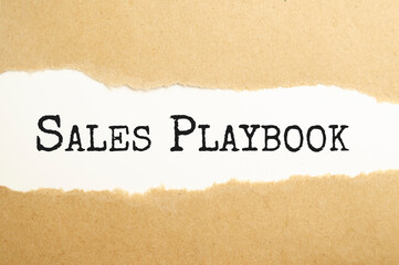 sales playbook text on torn paper on the white background with pen