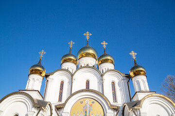 Lots of golden domes of the church close-up, against the backdrop of a bright blue sky.