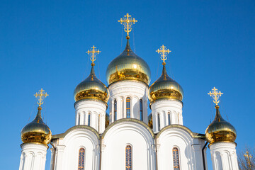 Lots of golden domes of the church close-up, against the backdrop of a bright blue sky.