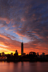 Fototapeta na wymiar Orange sunrise clouds over Gold Coast city scape silhouette