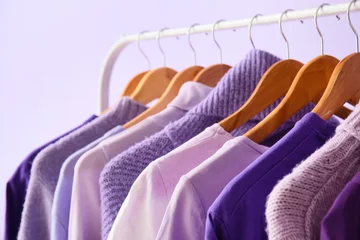 Keuken spatwand met foto Rack with clothes in purple shades on lilac background, closeup © Pixel-Shot