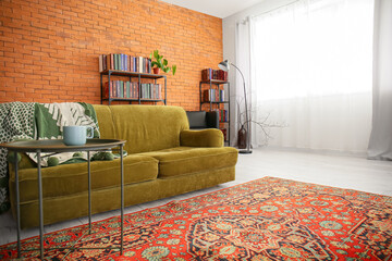 Interior of cozy living room with vintage carpet and green sofa
