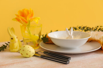 Easter egg and stylish setting on wooden table near color wall