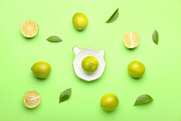 Ceramic juicer and limes on green background