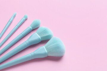 Set of makeup brushes on pink background, closeup
