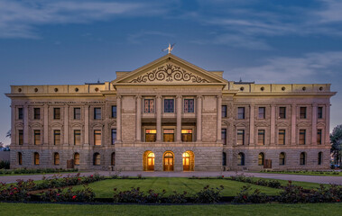 Illuminated Arizona State Capitol in Phoenix at dusk.  Beautiful glowing orange lights coming from...