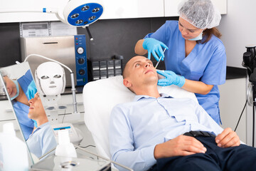 Obraz premium Portrait of man getting face skin rejuvenation treatments at beautician office