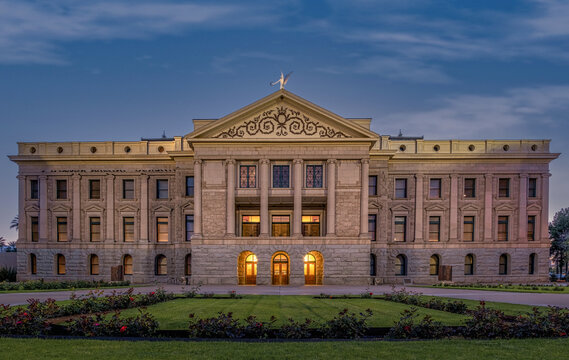 Arizona State Capitol in Phoenix at dusk.  Beautiful glowing orange lights coming from the windows lighting up the rose garden.