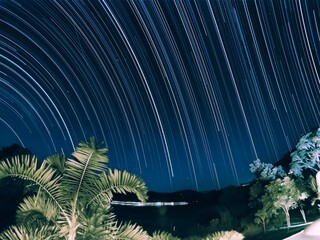 tropical island with palm trees and long exposure stars