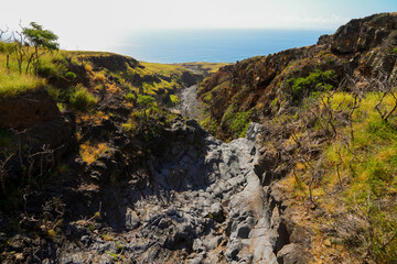 Fototapeta na wymiar Kamole Gulch along the Piilani Highway in the southeast of Maui island, Hawaii - Rocky dry river bed on the slopes of the Haleakala Volcano mountain