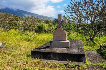 Christian grave in the cemetery of Saint Joseph Church, built in 1862 along the Piilani Highway in the south of Maui island in Hawaii - Religious building on the slopes of the Haleakala volcano - obrazy, fototapety, plakaty