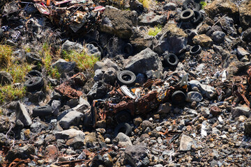 Rusted car wreck fallen off the road into Manawainui Gulch on the Piilani Highway in the southeast of Maui island in Hawaii, United States