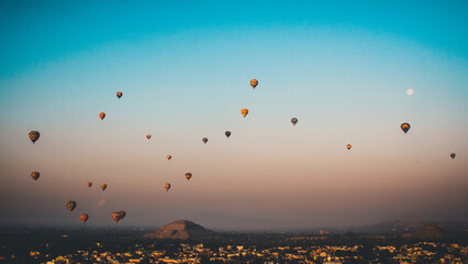 hot air balloons in the air over teotihuacan pyramid