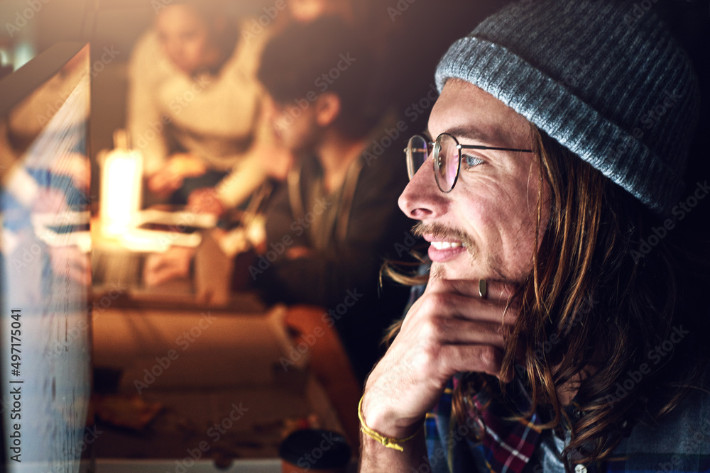 Poster looking at the big picture. cropped shot of a designer working on his computer on a night shift at w