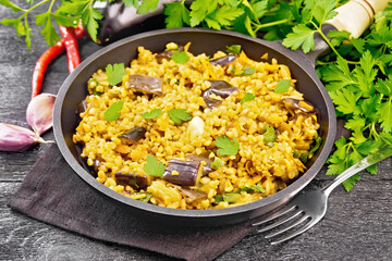 Bulgur with eggplant in pan on dark board