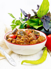 Meat with eggplant and pepper in bowl on white board