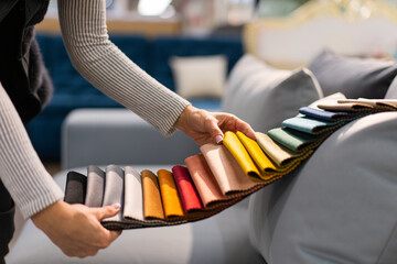 The woman chooses the fabric on the sofa. A young women looks at tissue samples. Selects the color...