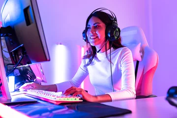 Fotobehang Gaming young  playing game online at home. Gamer  controlling joystick for video game. Teenage girls leisure game in neon light room at home.  © anon