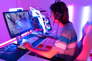 young  playing game online at home. Gamer  controlling joystick for video game. Teenage girls leisure game in neon light room at home.