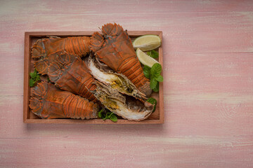 Flathead lobster on wooden background, Flathead lobster or Mantis shrimp on wooden plate ready to...