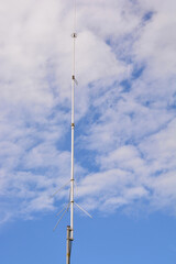Obraz premium Telecommunications antennas with cloudy blue sky in the background
