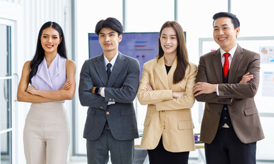 Asian young professional successful male and female businessmen and businesswomen in formal business suit standing side by side smiling holding hands bonding united together in company meeting room
