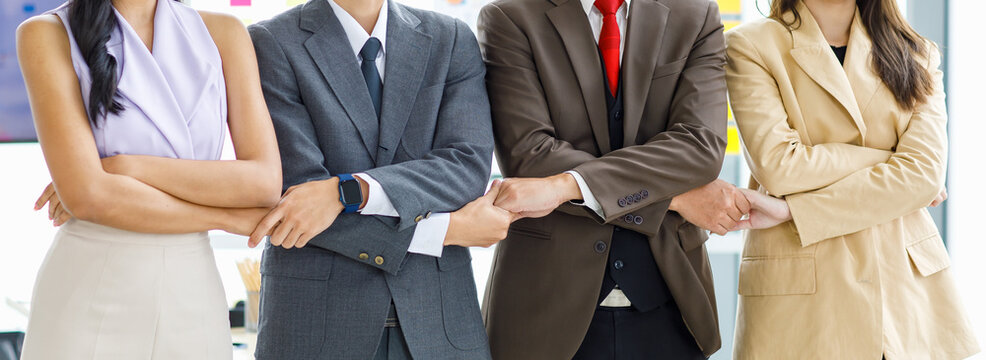 Asian Young Professional Successful Male And Female Businessmen And Businesswomen In Formal Business Suit Standing Side By Side Smiling Holding Hands Bonding United Together In Company Meeting Room