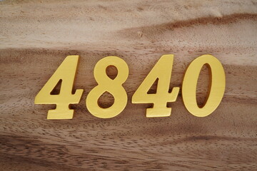 Golden Arabic numerals on a real brown and white wooden floor number 4840