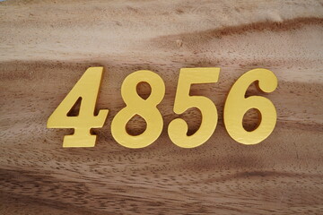 Golden Arabic numerals on a real brown and white wooden floor number 4856