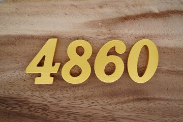 Golden Arabic numerals on a real brown and white wooden floor number 4860