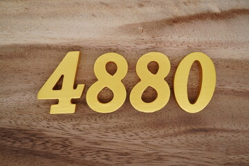 Golden Arabic numerals on a real brown and white wooden floor number 4880