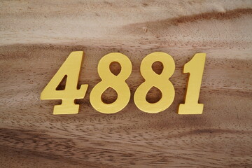 Golden Arabic numerals on a real brown and white wooden floor number 4881
