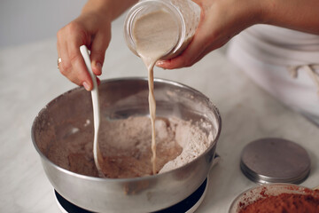 Chef in white clothes prepares a chocolate cake.