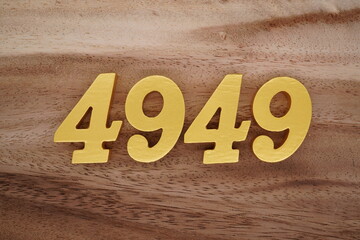 Golden Arabic numerals on a real brown and white wooden floor number 4949
