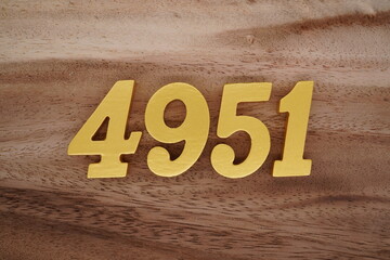 Golden Arabic numerals on a real brown and white wooden floor number 4951