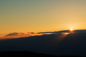 高ボッチ高原から見る日没間近でシルエットになった御嶽山と光芒さす山々