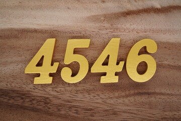 Golden Arabic numerals on a real brown and white wooden floor number 4546