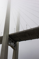 Fototapeta premium a beautiful bridge over the sea disappears in the fog. the bridge dissolves into the sky.