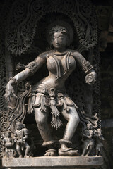 Stone Sculpture of Beautiful Female (Madanikas) with selective focus, 12th century Hindu temple, Ancient stone art and sculptures in each pillars, Chennakeshava Temple, Belur, Karnataka, India.