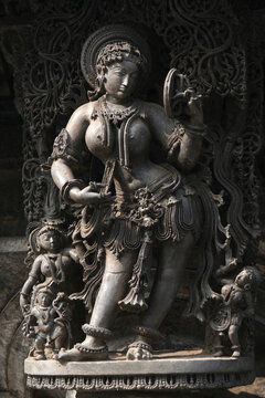 Stone Sculpture of Beautiful Female (Madanikas) with selective focus, 12th century Hindu temple, Ancient stone art and sculptures in each pillars, Chennakeshava Temple, Belur, Karnataka, India.