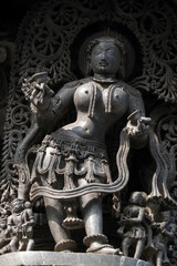 Stone Sculpture of Beautiful Female (Madanikas) with selective focus, 12th century Hindu temple, Ancient stone art and sculptures in each pillars, Chennakeshava Temple, Belur, Karnataka, India.