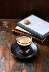 Coffee in glass cup on rustic wooden background.